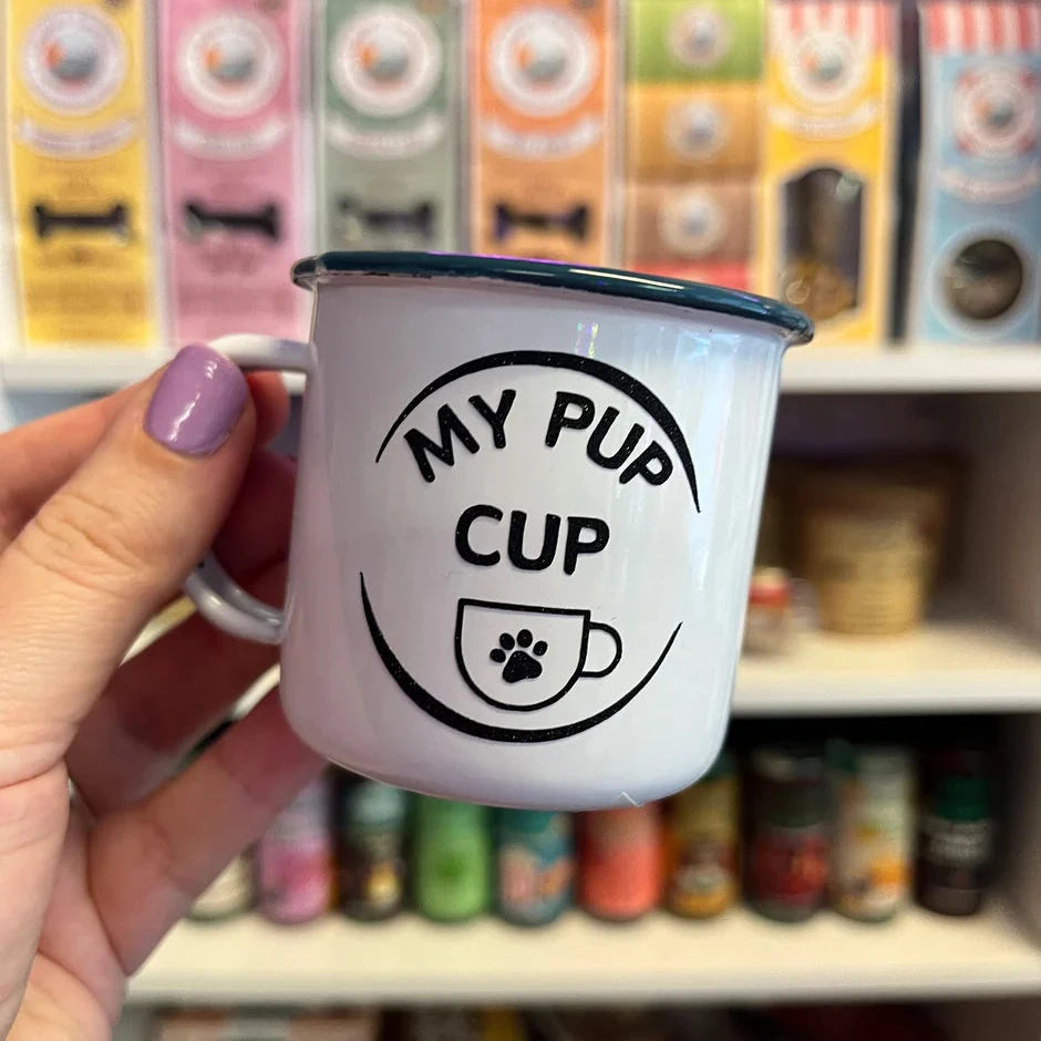 Close up of an espresso cup with a circle, and writing saying my pup cup and a cup with a paw print motif