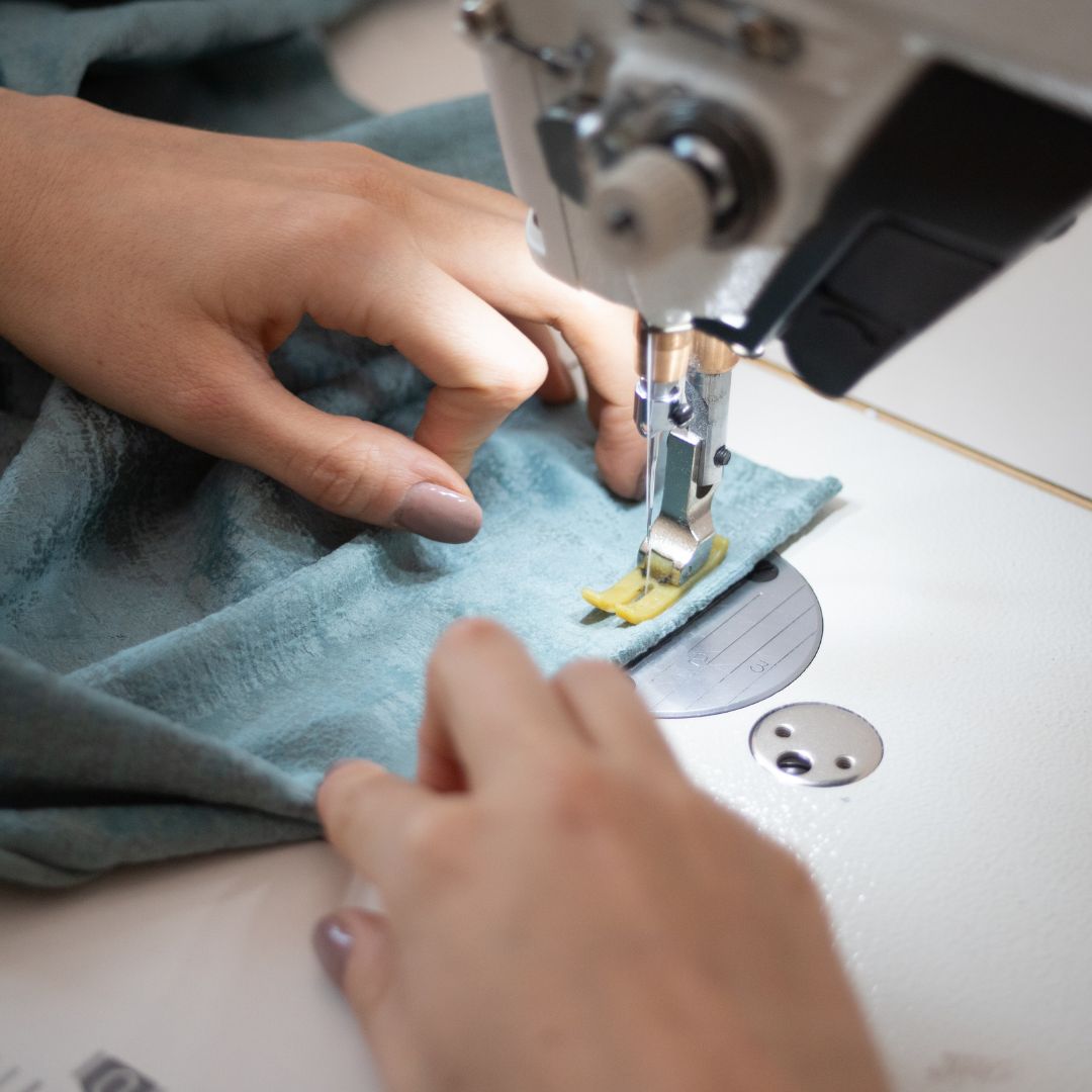 Person using a sewing machine on a piece of fabric