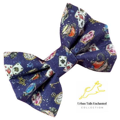 A dog bow tie with a navy cotton fabric  featuring Alice in Wonderland elements, playing cards, tea cups, tea pot and watch pattern.