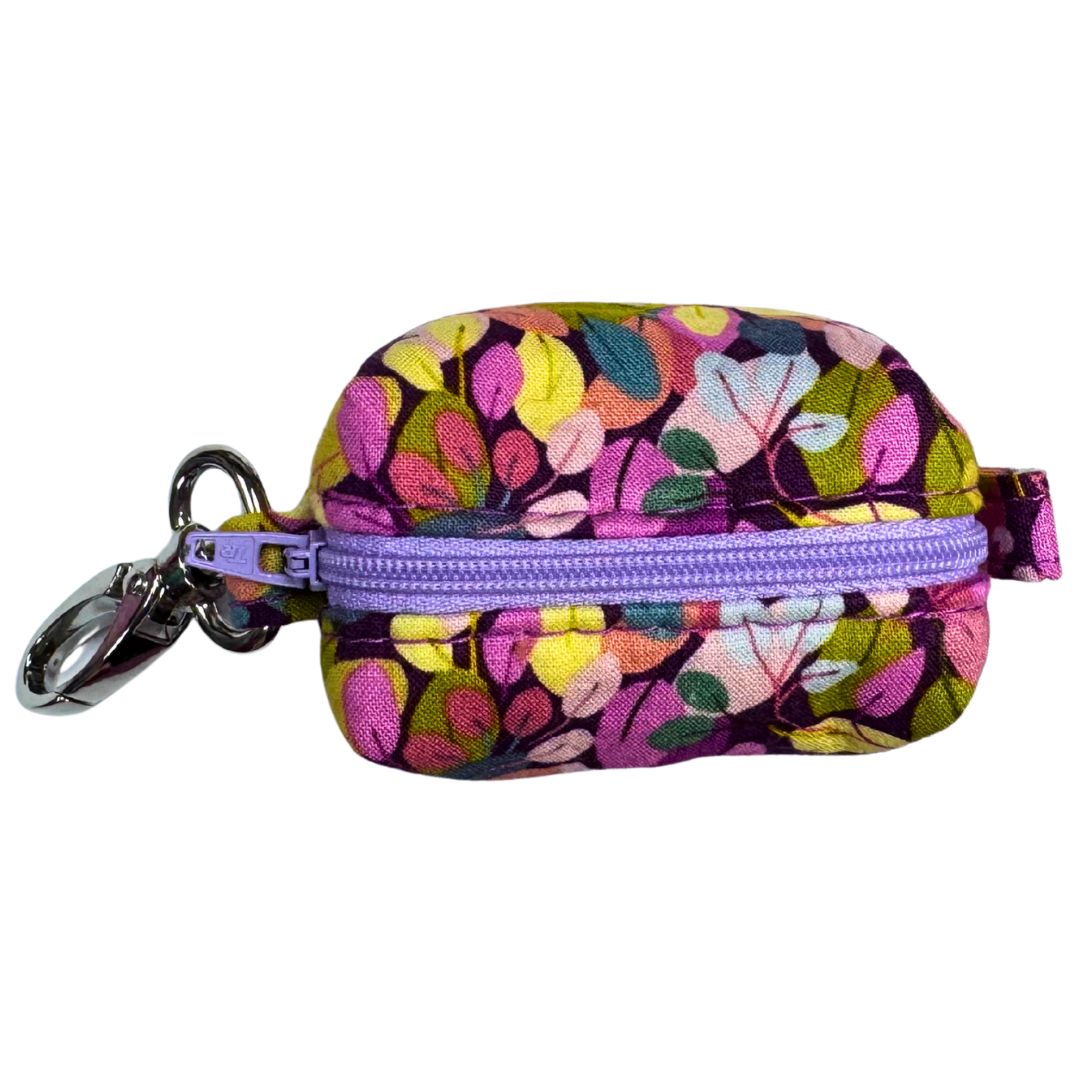 Colourful floral-patterned poo bag holder with a purple zipper.