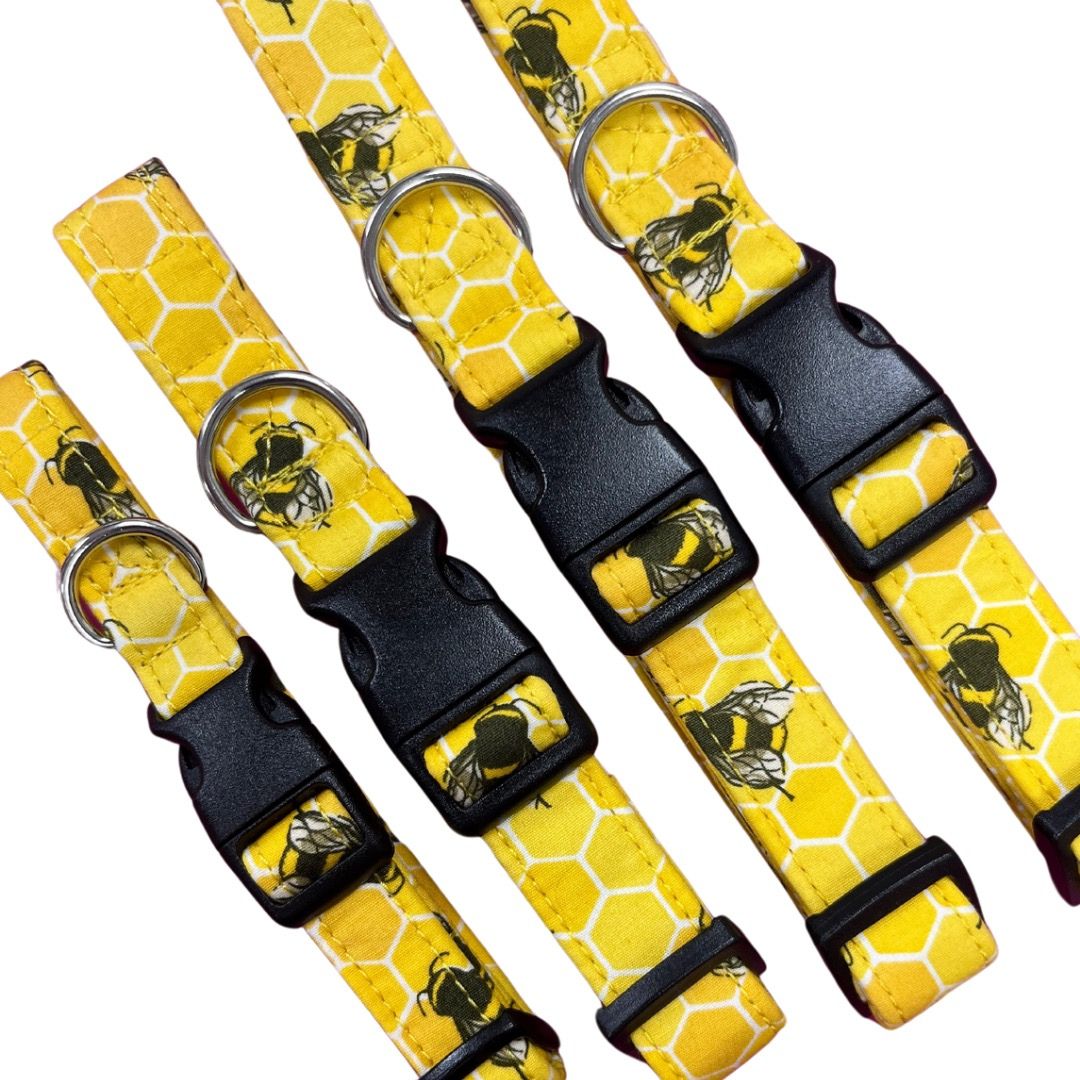 A collection of yellow dog collars with a bee hive print and plastic buckles.