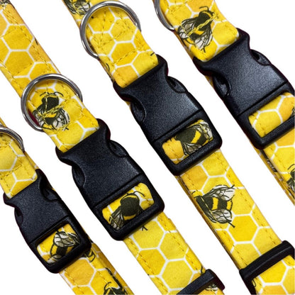 A collection of yellow dog collars with a bee hive print and plastic buckles.