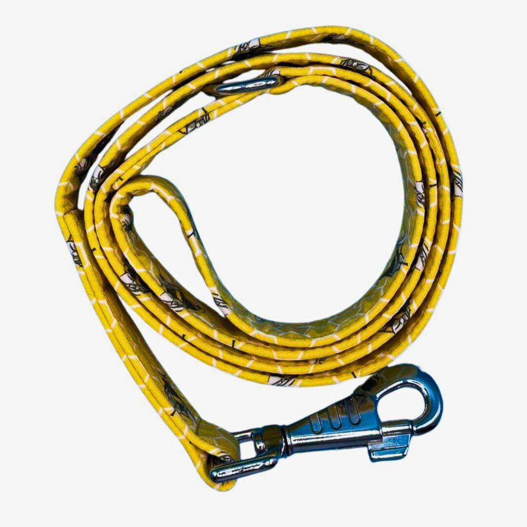 A coiled yellow dog lead with a honeycomb pattern and bees, featuring silver metal hardware and a blue swivel clip.