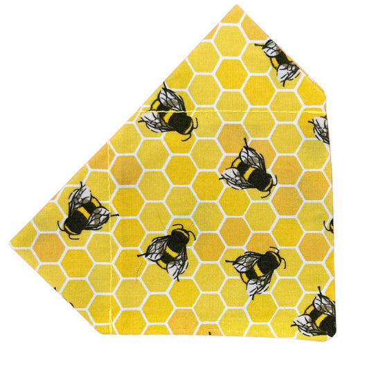 A yellow dog bandana with a bee hive and bee pattern
