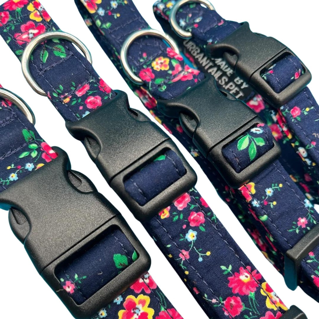 A close up of four adjustable dog collars with a floral pattern and plastic buckles, in various sizes.