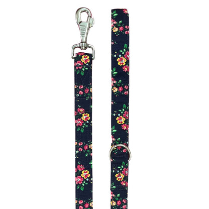 A dog lead with a navy base covered in a floral pattern, featuring silver metal hardware.