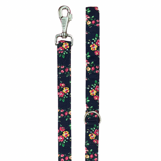 A dog lead with a navy base covered in a floral pattern, featuring silver metal hardware.