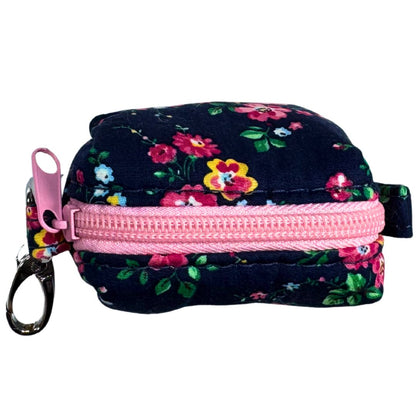 A top view of a fabric poo bag holder with a floral pattern, featuring a metal accessory and a colour pink zip.