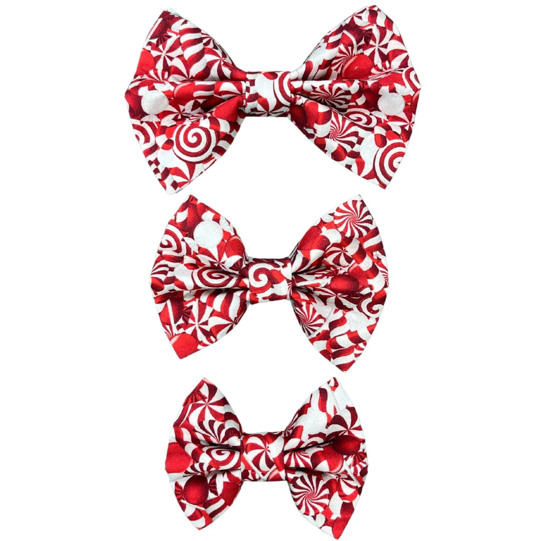 Three handmade holiday candy cane print bow accessory for dog collars - red and white festive design.