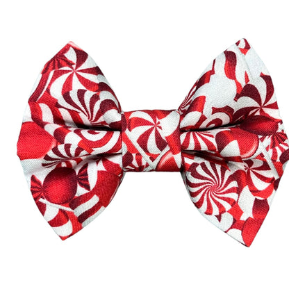 Handmade holiday candy cane print bow accessory for dog collars - red and white festive design.