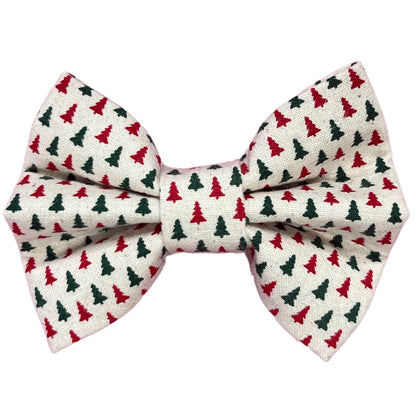 A handmade dog bow tie with red and green Christmas trees on a white background.
