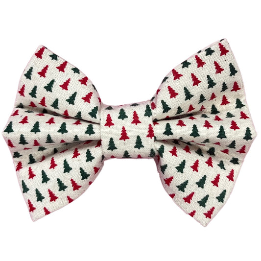 A handmade dog bow tie with red and green Christmas trees on a white background.