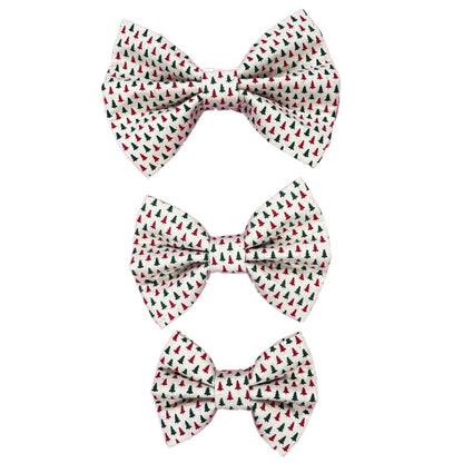 Three handmade dog bow ties in small, medium and large with red and green Christmas trees on a white background.