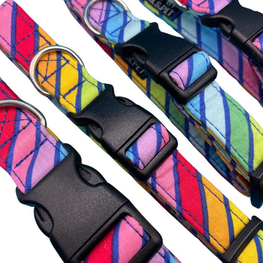 A close up of a collection of colourful striped dog collars with plastic buckles and metal D rings.