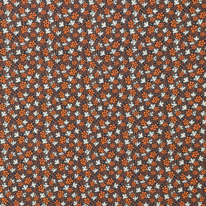 Pattern of ladybugs and flowers on a brown background