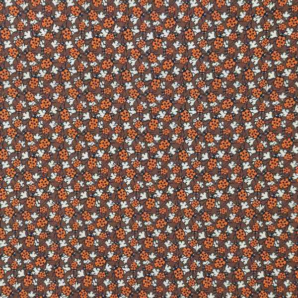 Pattern of ladybugs and flowers on a brown background