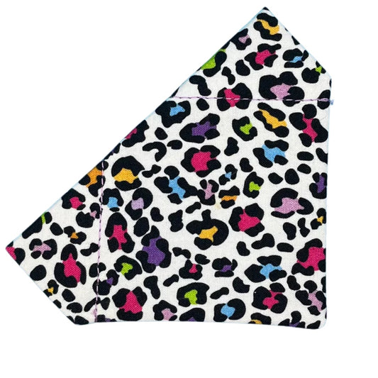 A multicoloured leopard print dog bandana in black, white, and various bright colours.