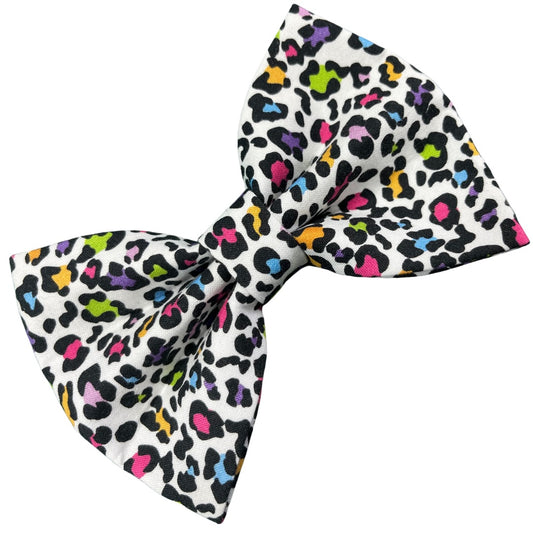 A multicoloured leopard print dog bow in black, white, and various bright colours.