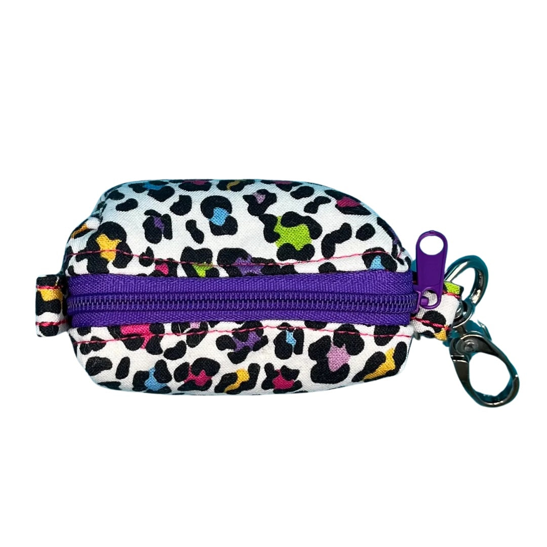 A top view of a multicoloured leopard print fabric poo bag holder with metal accessories and a Purple contrasting zip.