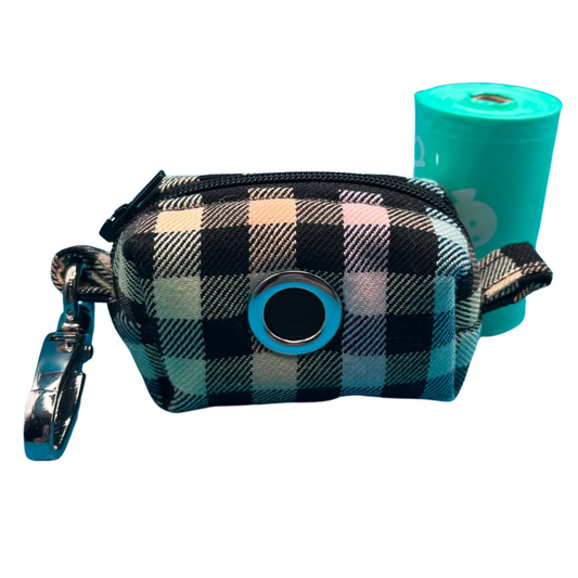 A fabric poo bag holder with a checkered pattern in rainbow colours, featuring a metal accessory and a roll of green poo bags.