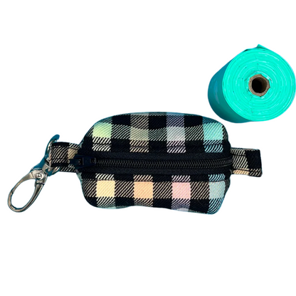 A fabric poo bag holder with a checkered pattern in rainbow colours, featuring a metal accessory and a roll of green poo bags.