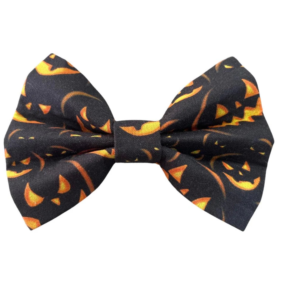 Halloween-themed bow with jack-o'-lantern design on a black background