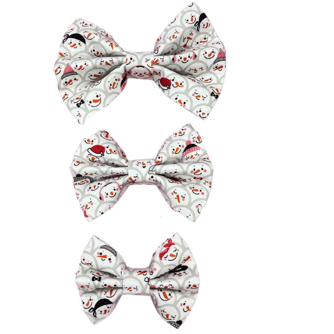 Three bow ties with a Christmas-themed pattern featuring smiling snowmen