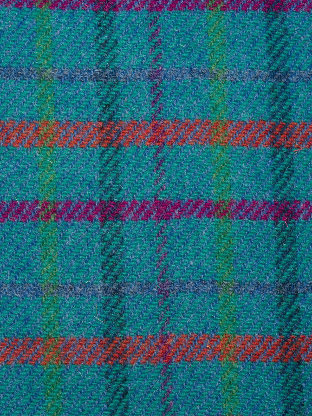 Close-up of a Harris Tweed Tartan fabric featuring blue, green, and orange colours.