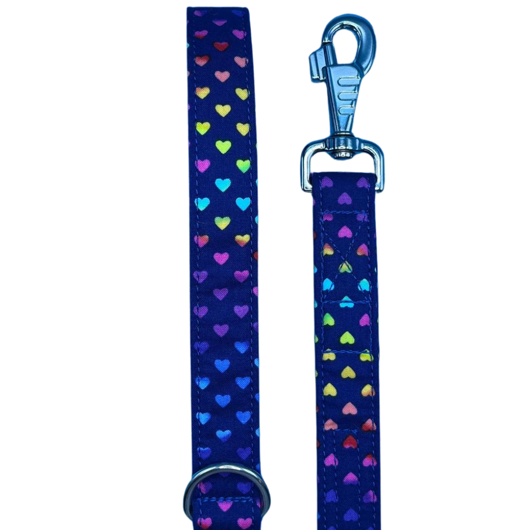 A dog lead with a navy background and multicolored heart polka dot pattern, featuring a metal swivel clip and D ring.
