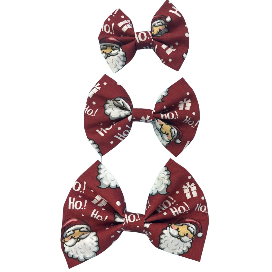 Three handmade red bow ties with text 'ho ho ho' and images of Santa Claus and presents