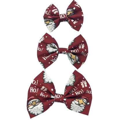Three handmade red bow ties with text 'ho ho ho' and images of Santa Claus and presents