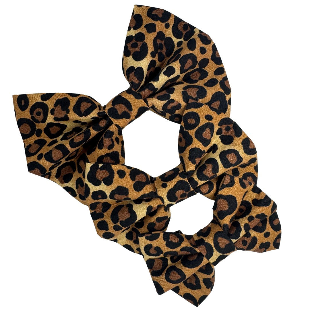 Three brown and black animal print fabric dog bows.