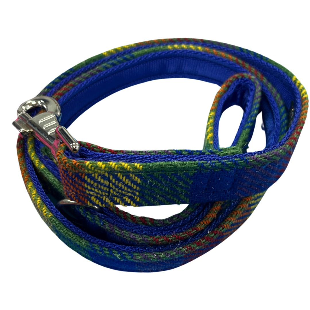 A colourful striped tartan dog lead with a metal clasp, colours are a mix of blue, green, orange, and yellow patterns.