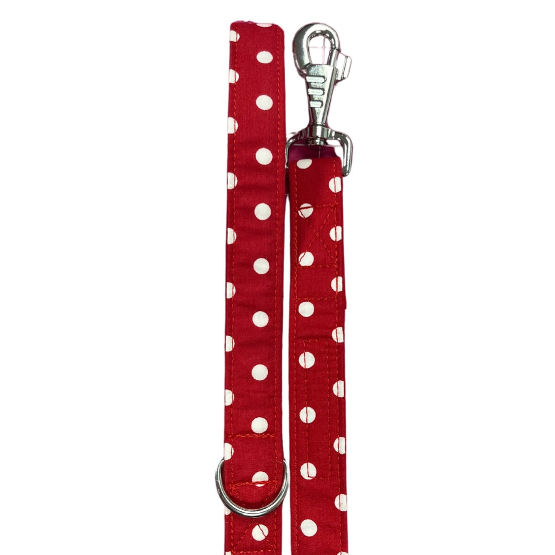 A red dog lead with white polka dots and a metal clasp.