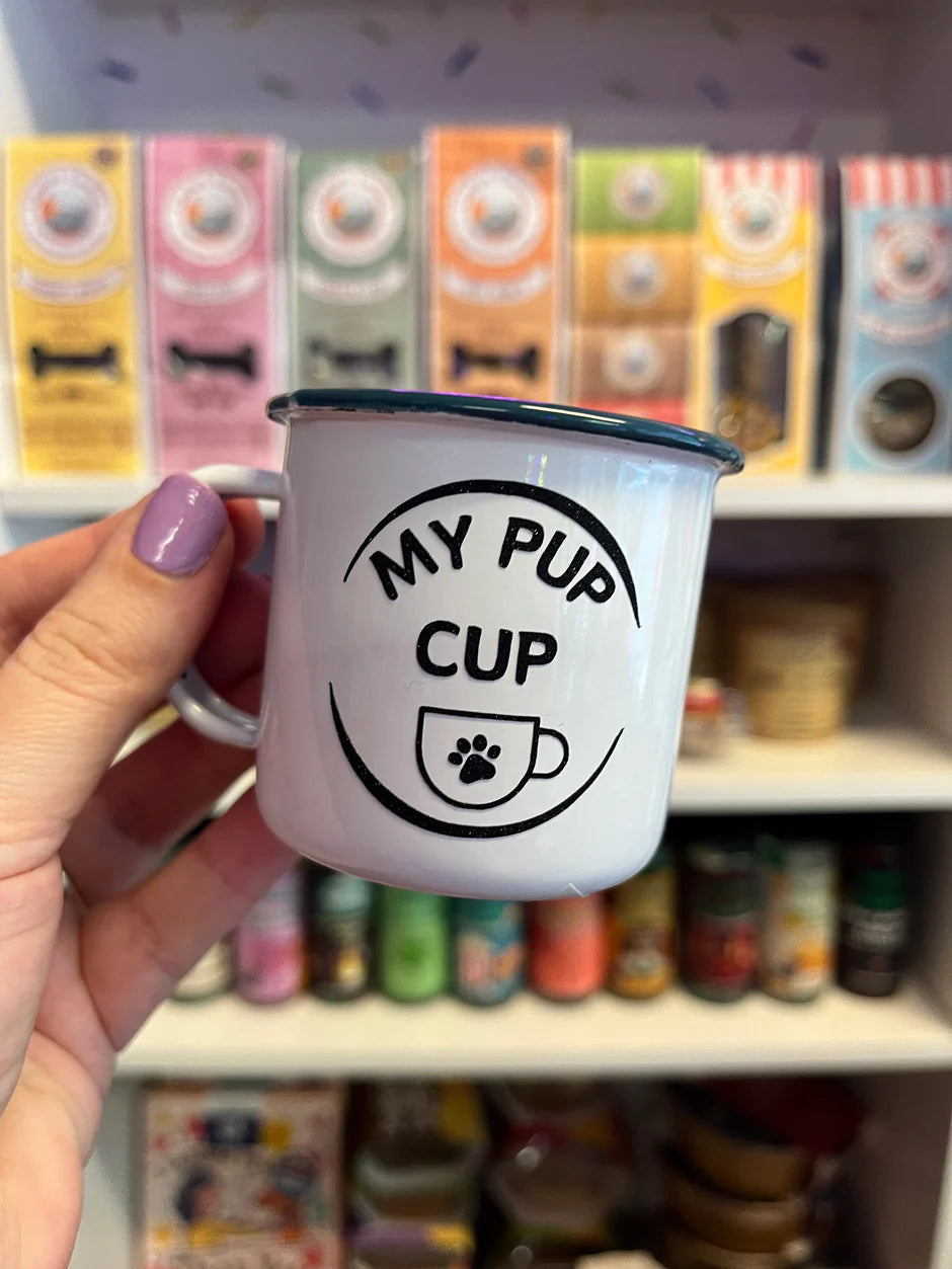 Close up of an espresso cup with a circle, and writing saying my pup cup and a cup with a paw print motif