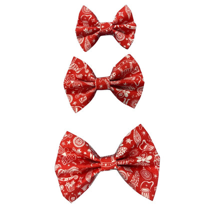Three red handmade dog bow ties in small, medium and large with a Christmas-themed pattern that includes a rocking horse, baubles and a mouse