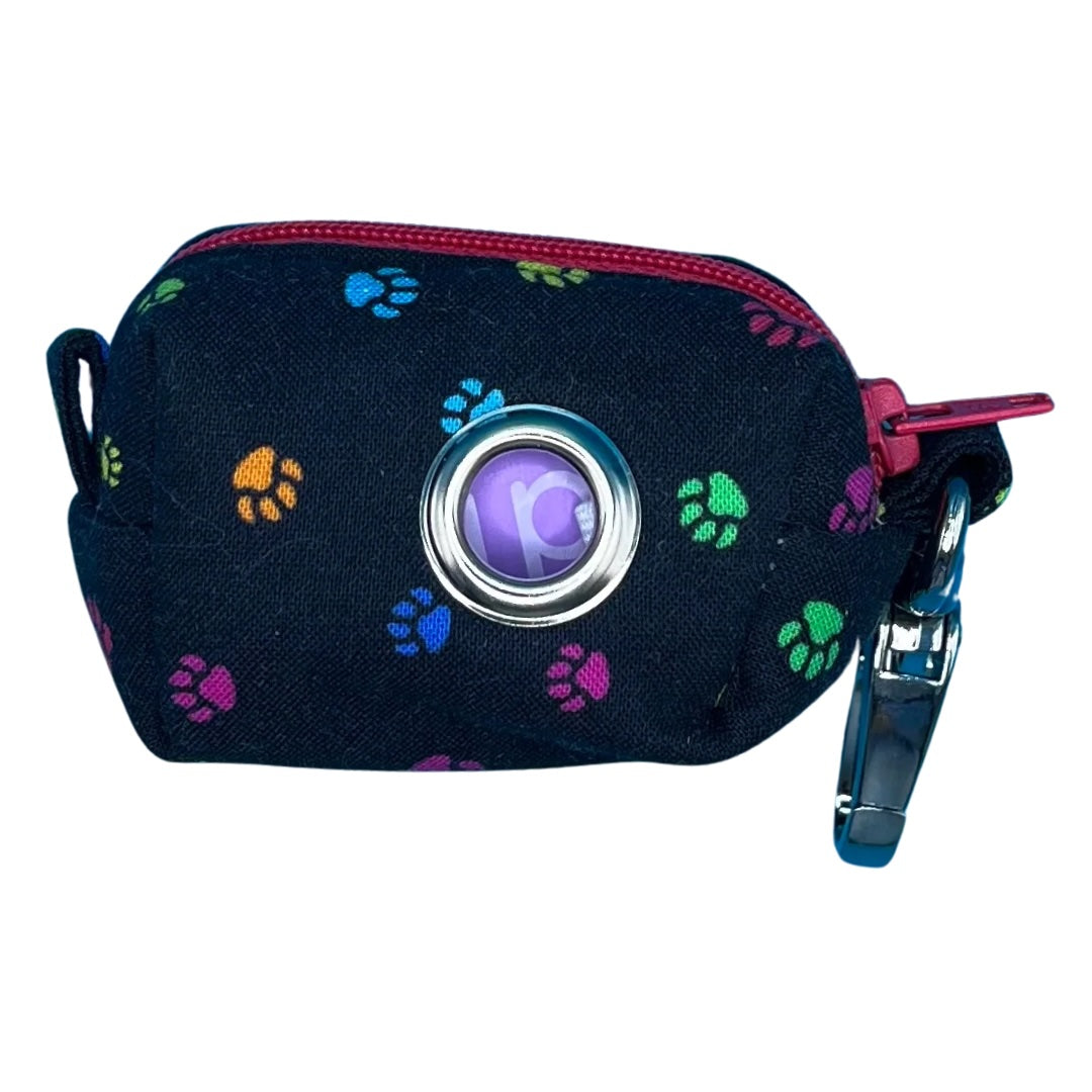 A fabric poo bag holder with a paw print pattern, multicoloured edges, and a pink zipper.