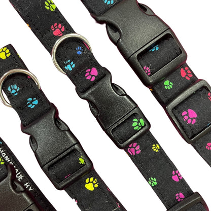 Adjustable dog collar with a paw print pattern, featuring a plastic buckle and  metal D-ring.