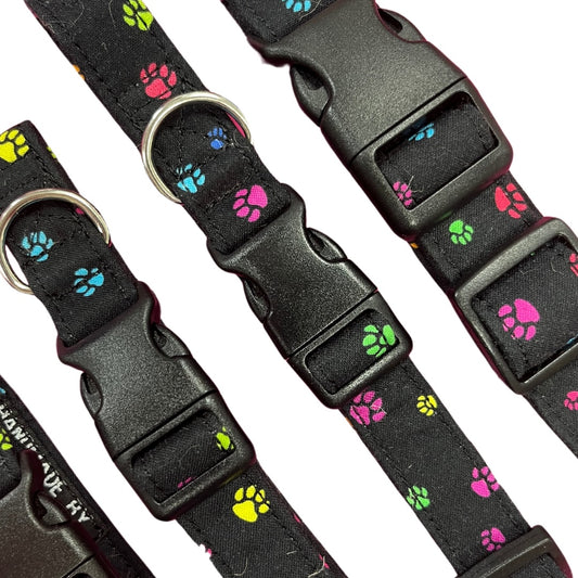 Adjustable dog collar with a paw print pattern, featuring a plastic buckle and  metal D-ring.