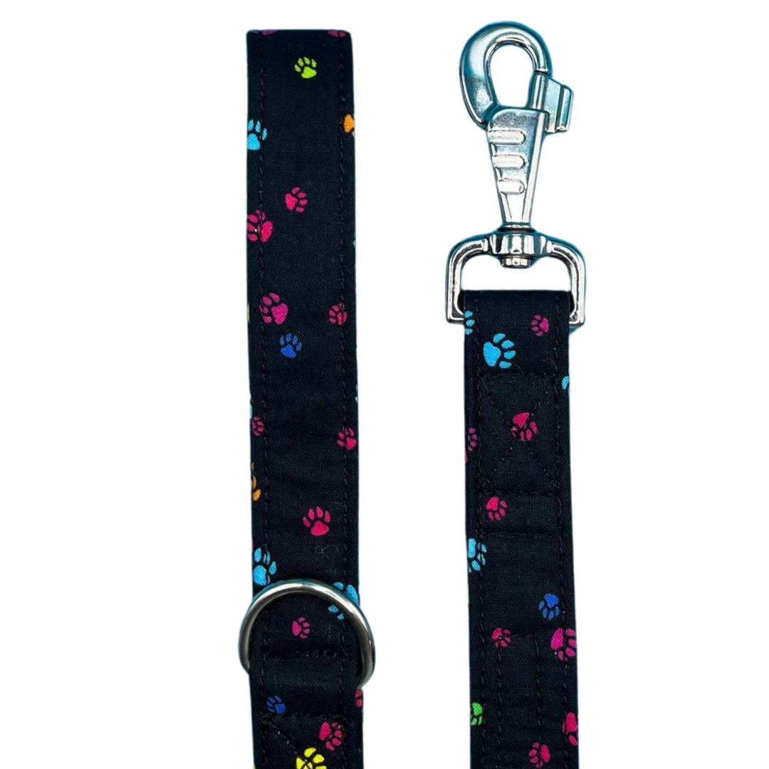 A black dog lead with a pattern of colorful paw prints and a metal clasp for attachment.