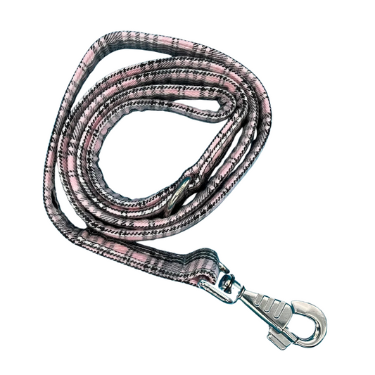 A pink and grey sugar tartan dog lead with silver metal hardware, Swivel clip for attaching to a dog's collar and a metal D ring for accessories.