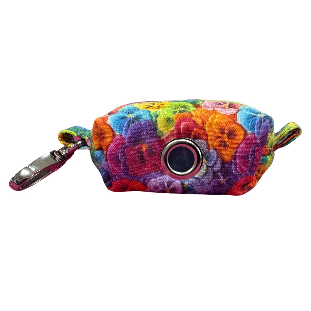A colourful floral fabric poo bag holder with metal accessories and a green zipper.