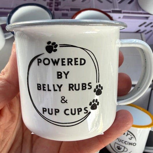 White mug with 'Powered by Belly Rubs & Pup Cups' text held in a hand.