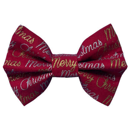 A red bow tie with 'Merry Christmas' text and gold and silver accents.