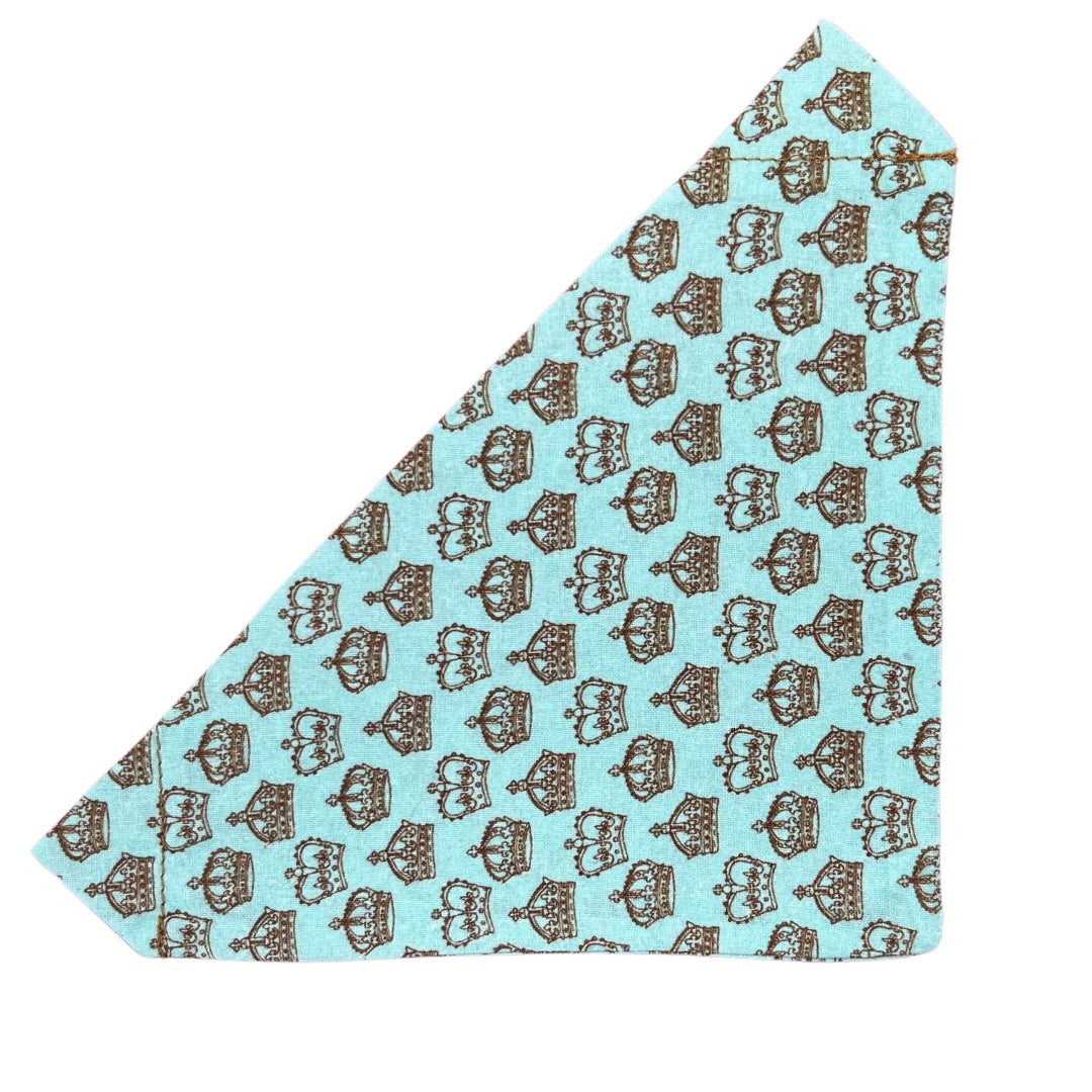 A blue handmade over the collar bandana with a print of brown crowns.