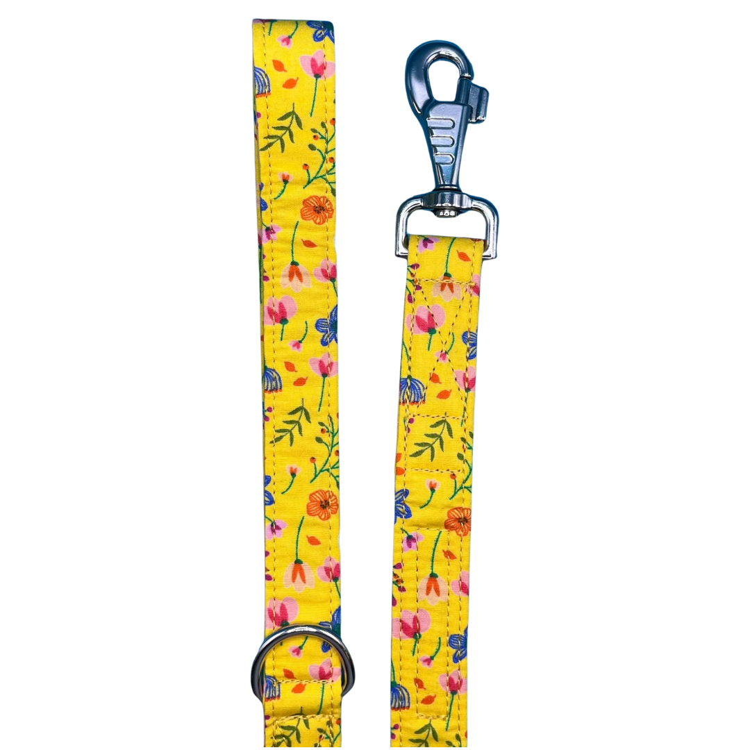 A yellow dog lead with a floral pattern, including a metal swivel clip and D ring.