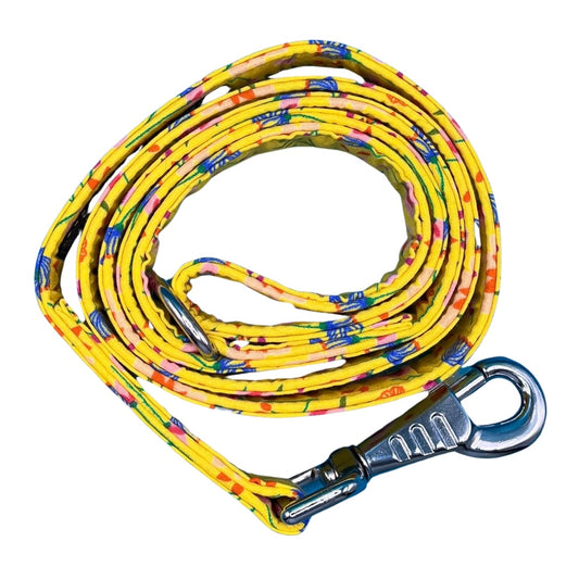 A coiled yellow dog lead with a floral pattern, including a metal swivel clip and D ring.