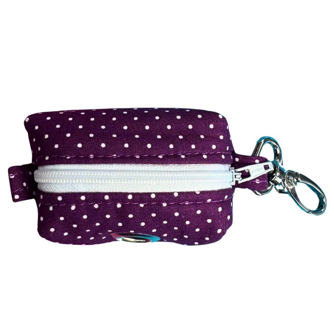 Purple polka dot poo bag pouch with a white zipper and metal clasp on a white background