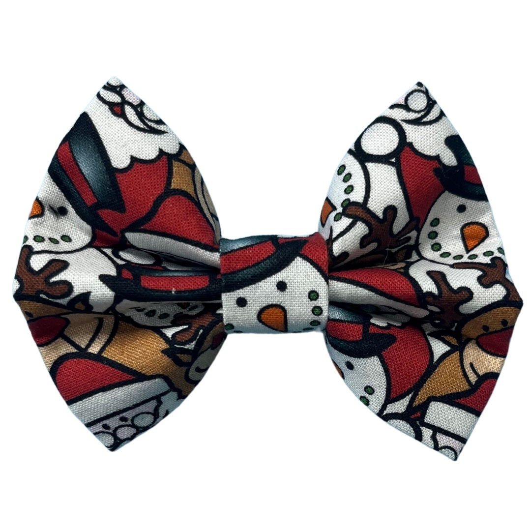 A festive bow tie with a Christmas-themed pattern featuring Santa, snowmen and reindeer on a red and white background.