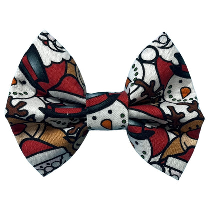A festive bow tie with a Christmas-themed pattern featuring Santa, snowmen and reindeer on a red and white background.